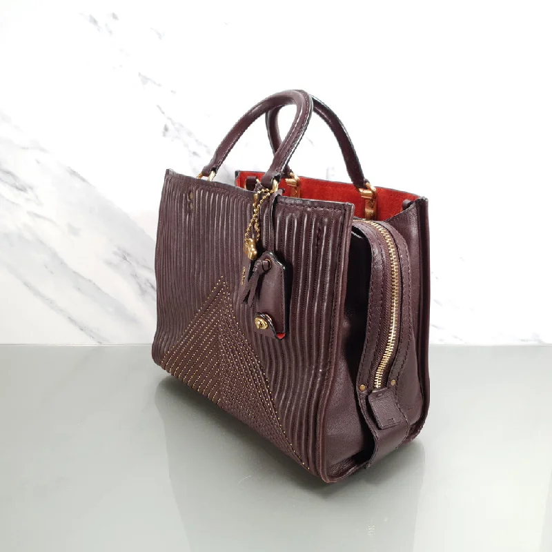 Coach handbags with a perforated leather detail for a breathable and unique designCoach Rogue 31 in Oxblood Quilted Nappa Leather Chevrons with Studs & Red Suede - SAMPLE BAG