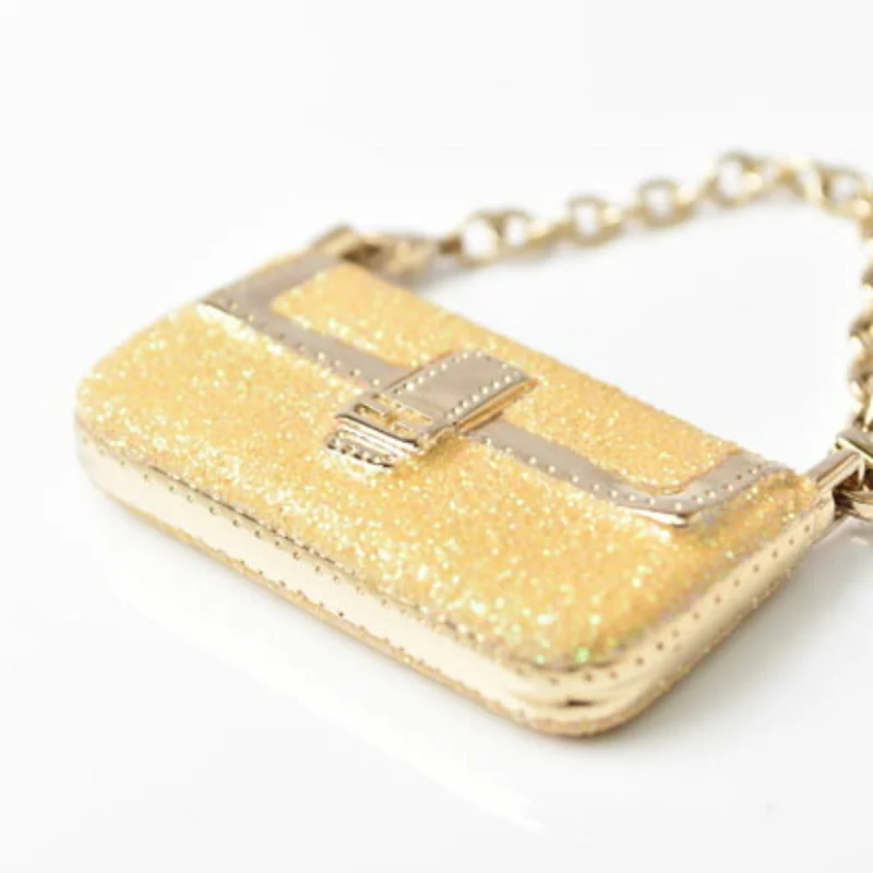 Fendi Baguette bags with a detachable charm featuring the brand's mascotFendi Keychain Bag Charm FENDI Mamma Bucket Motif Metallic Yellow Gold Metal