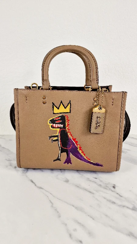 Coach handbags with a beaded trim for a glamorous and elegant lookCoach x Jean-Michel Basquiat Rogue 25 Pez Dispenser Dinosaur Bag in Elm Leather & Suede - Handbag Crosbody Shoulder Bag in Taupe Beechwood - Coach 6889